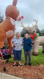 Resident stand in front of two large reindeer inflatable decoations